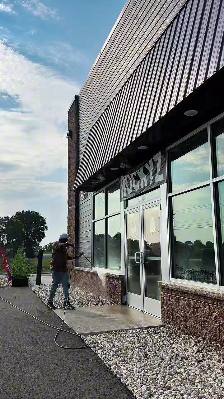 North Standard worker pressure washing a storefront exterior